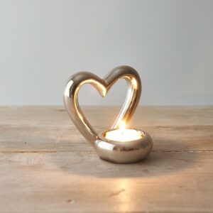 Silver Heart Tea Light Holder with lit tea light on a wooden table