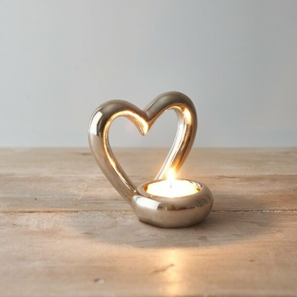 Silver Heart Tea Light Holder with lit tea light on a wooden table